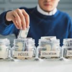 Hand's man putting money in jar for future, money plan, save money and management concept
