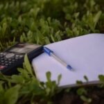 blue ballpoint pen on paper beside calculator