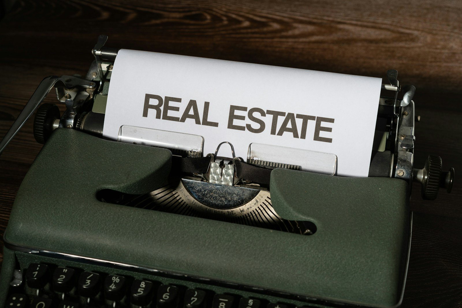 a close up of a typewriter with a real estate paper on it