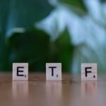 A wooden block spelling the word etf on a table